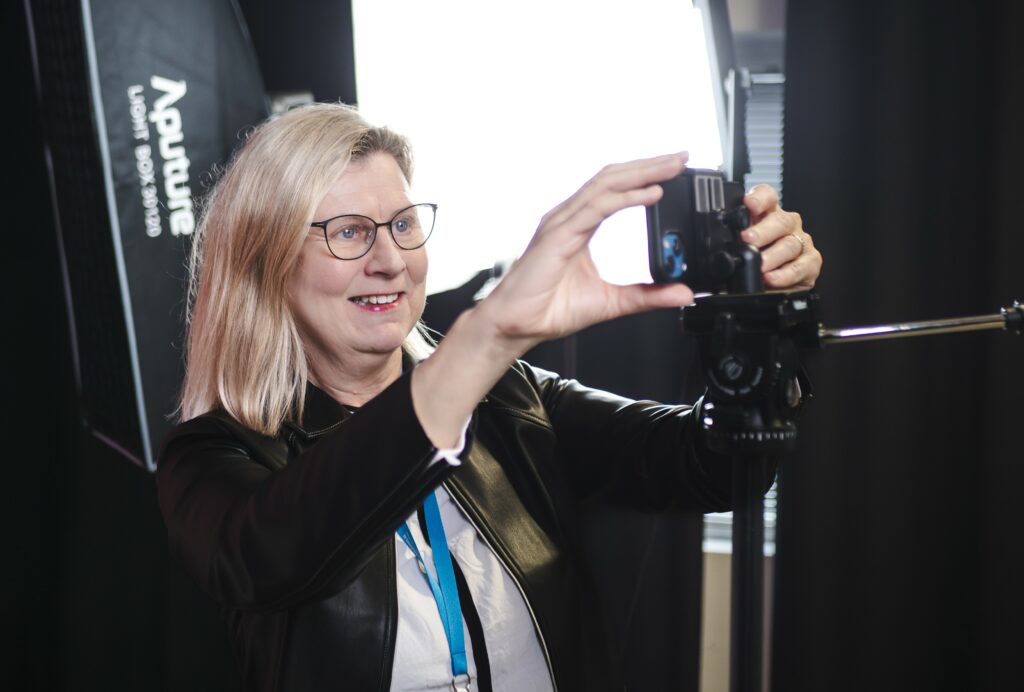 Marjo Ritmala asentaa puhelinta kamerajalustaan.